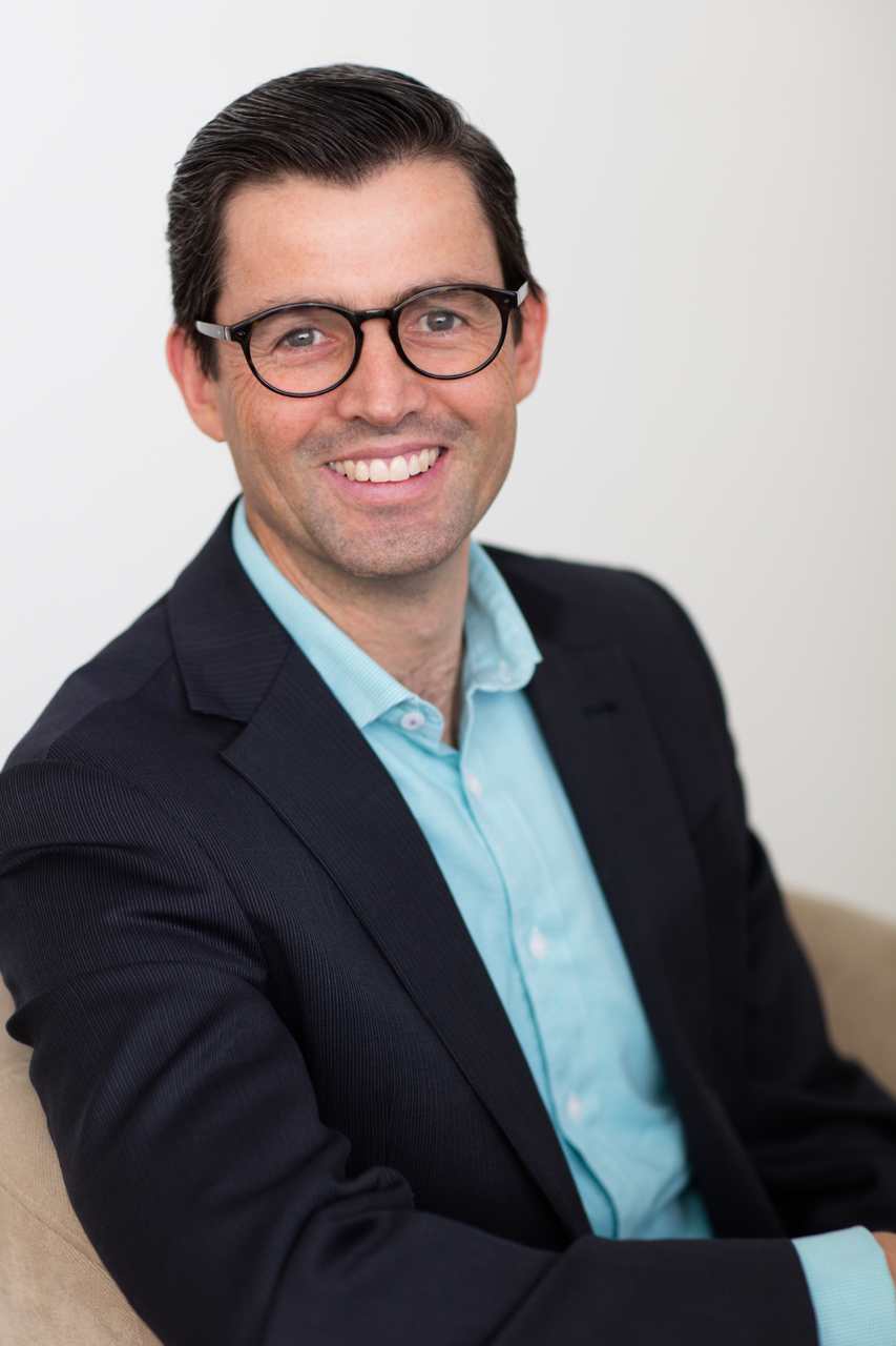 Relaxed Melbourne business headshot on white background in chair i